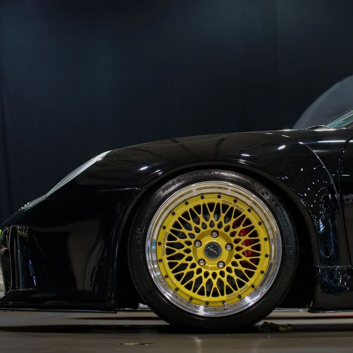 Gold mesh wheel on a black sports car